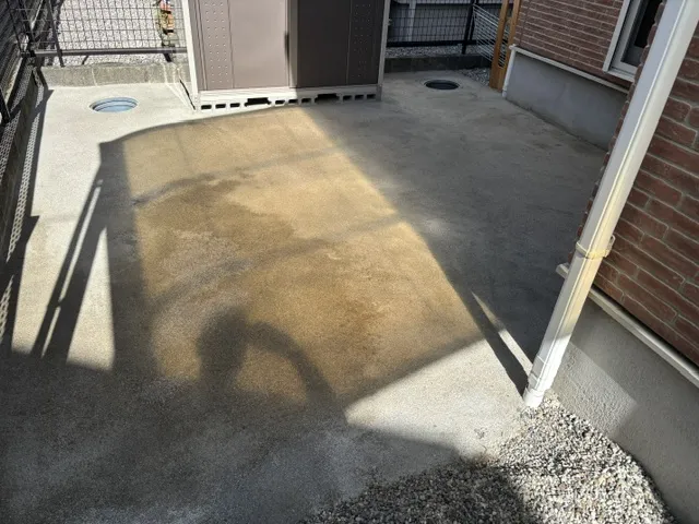 住宅の裏手に作った人工芝の下地。物置の際まで平らにならし、排水口のまわりも丁寧に仕上げている