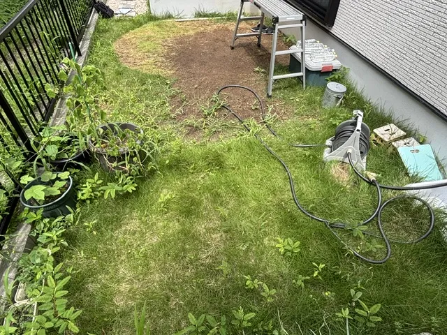 施工前の庭。日差しの下で雑草が伸び、地面がむき出しになっている部分もある